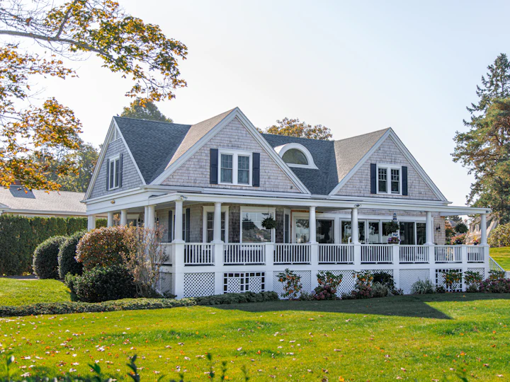 Einfamilienhaus mit Veranda und Rasen im Herbst